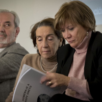 En primer plano, Nativel Preciado observa el dossier de prensa en homenaje a Pepe Oneto. Detrás, Pablo Sebastián y Victoria Prego