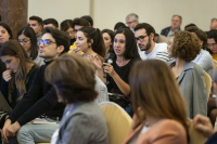 Una persona del público formula una pregunta a los ponentes